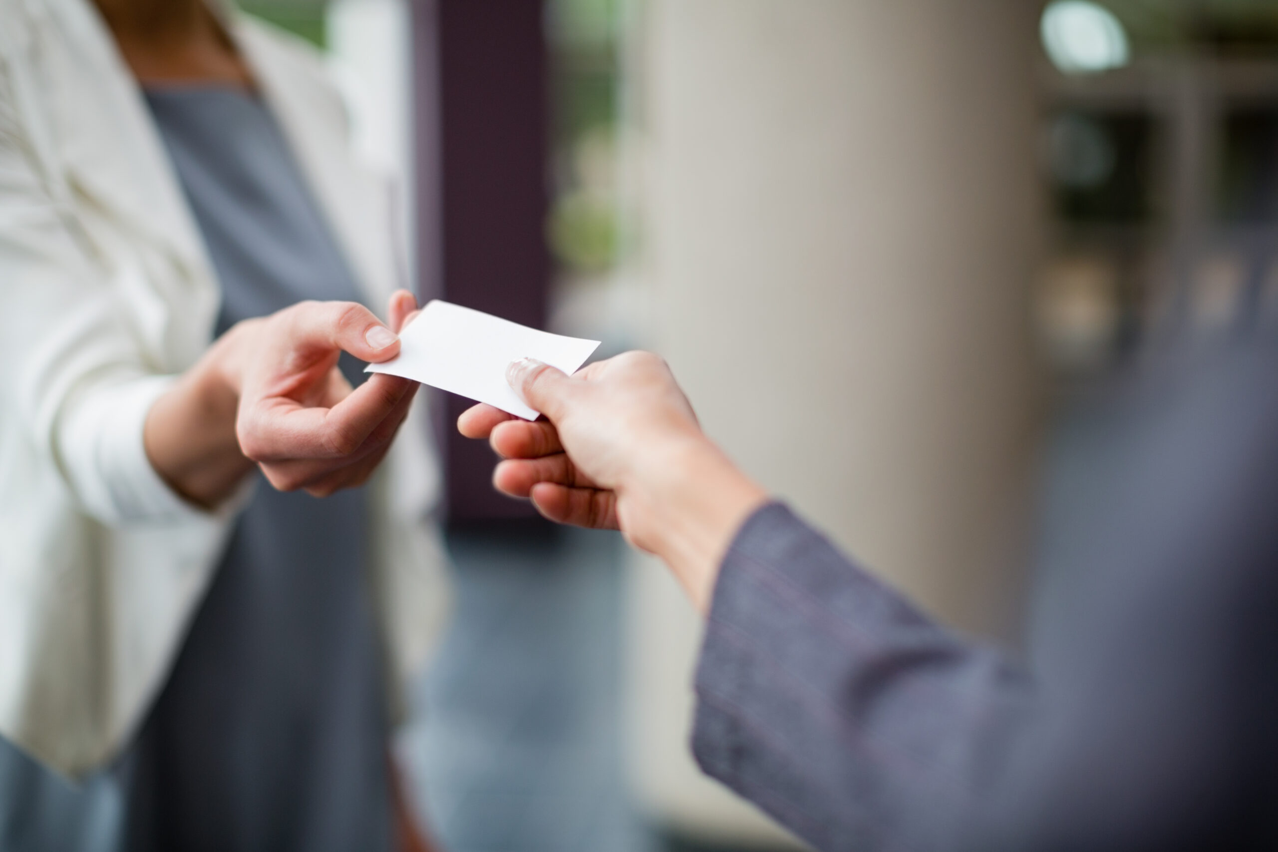 Close-up of business executives exchanging business card at conference centre